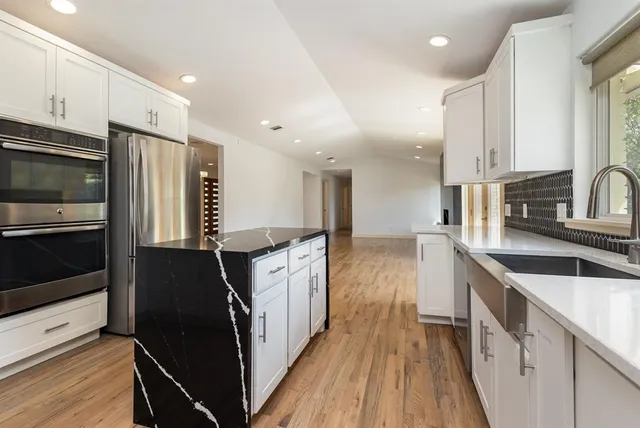 a kitchen with stainless steel appliances a refrigerator sink and microwave