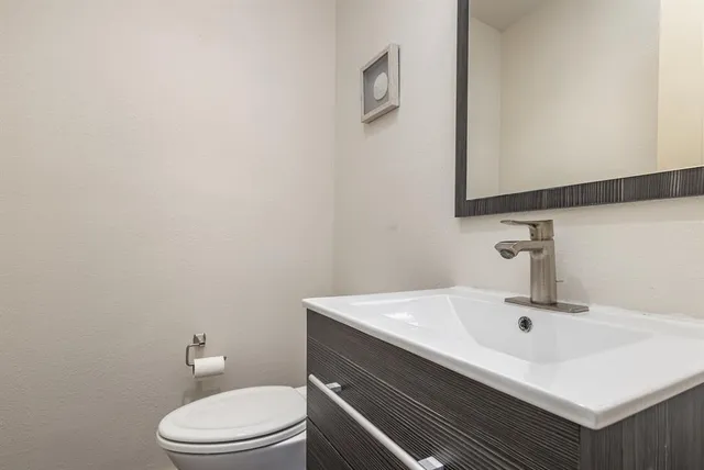 a bathroom with a sink a toilet and mirror