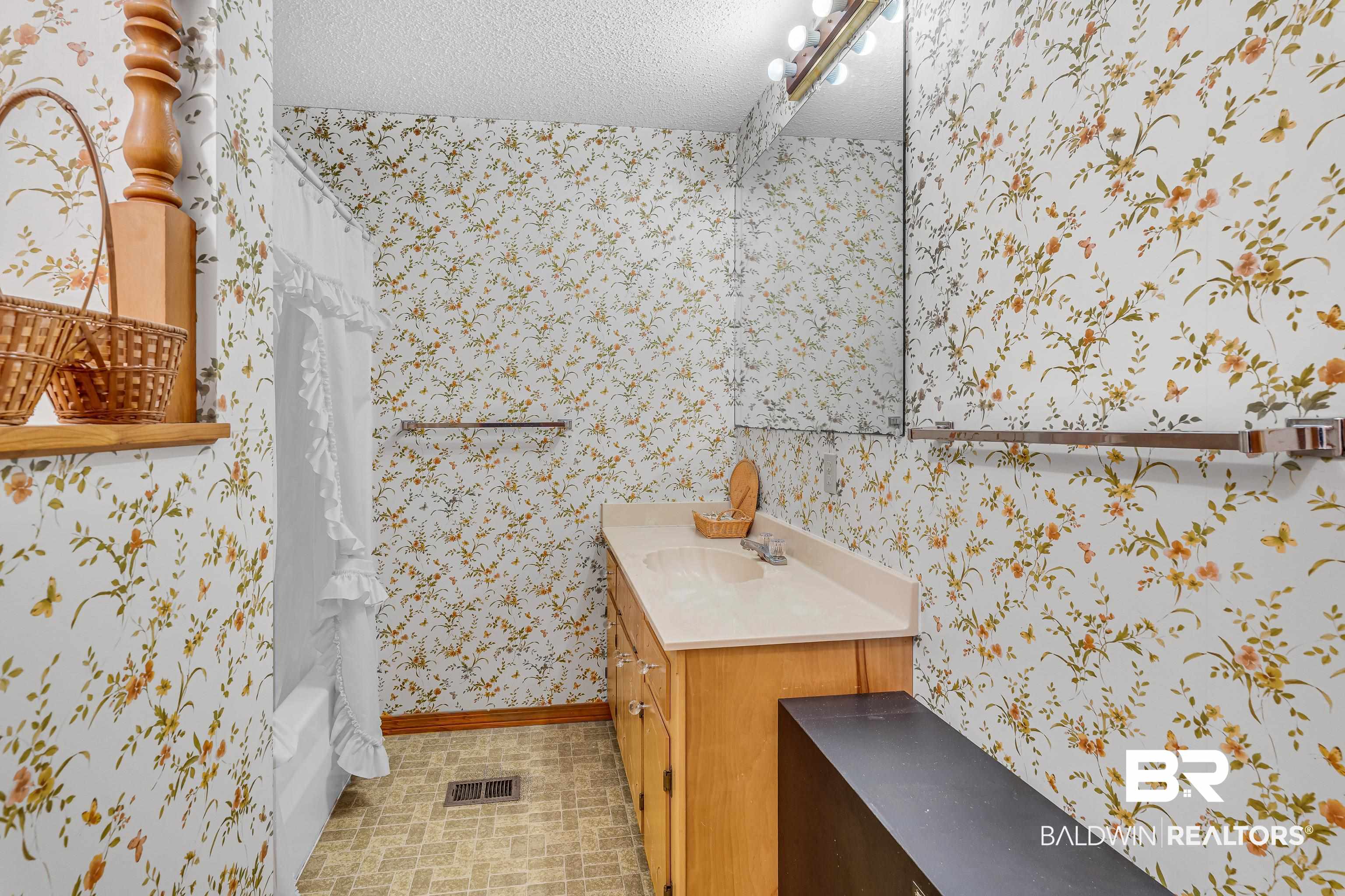 72075 Highway 59 Little River, AL 36550 - Photo 23 of 40 Bathroom featuring a textured ceiling, shower / tub combo with curtain, vanity, and wallpapered walls