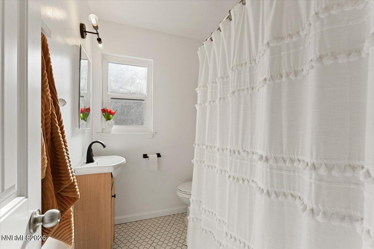 736 Yori Avenue Reno, NV 89502 - Photo 19 of 35 a bathroom with a sink a toilet and shower curtain