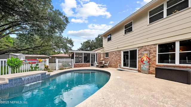 a view of a house with swimming pool and sitting area