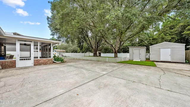 a view of a house with a yard and large tree