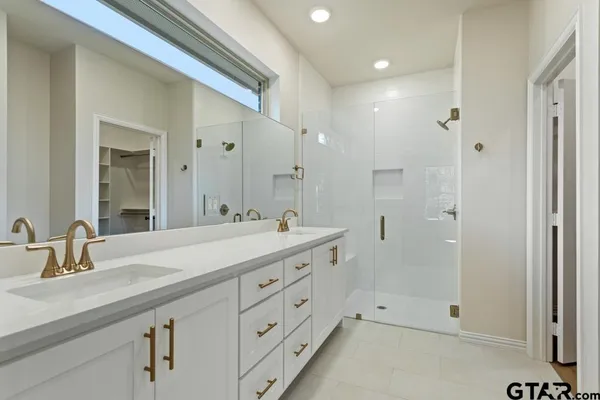 a bathroom with a sink a shower and mirror