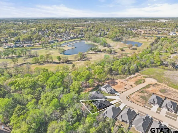 a front view of a house with a garden and trees