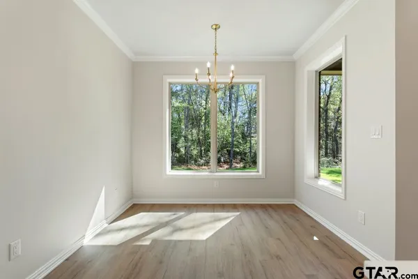 a view of a kitchen with wooden floor and a window