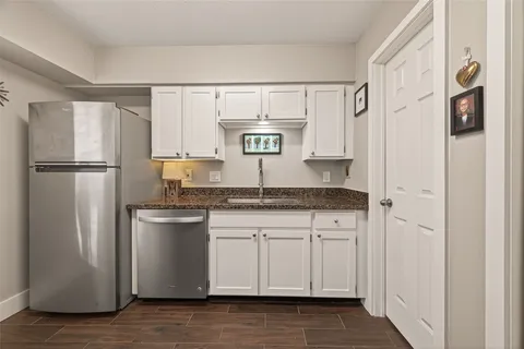 a kitchen with stainless steel appliances granite countertop a refrigerator and a sink