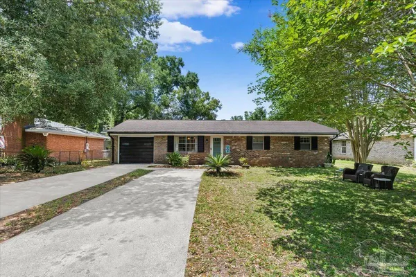 a front view of a house with yard patio and green space