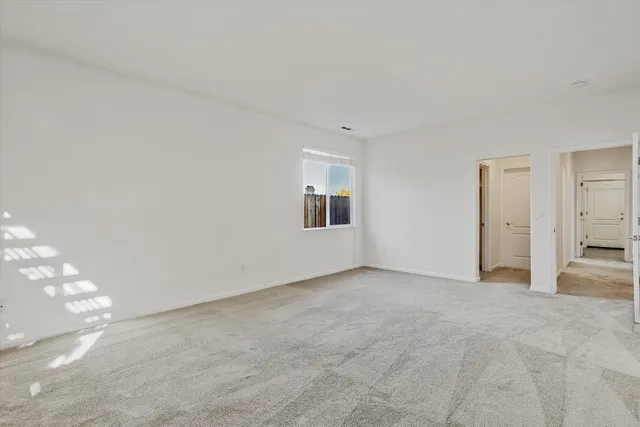 a view of a big room with windows and chandelier fan