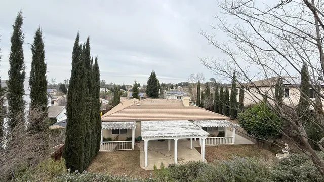 a patio with table and chairs and potted plants