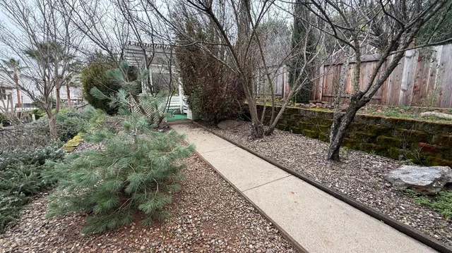 a view of backyard with wooden fence