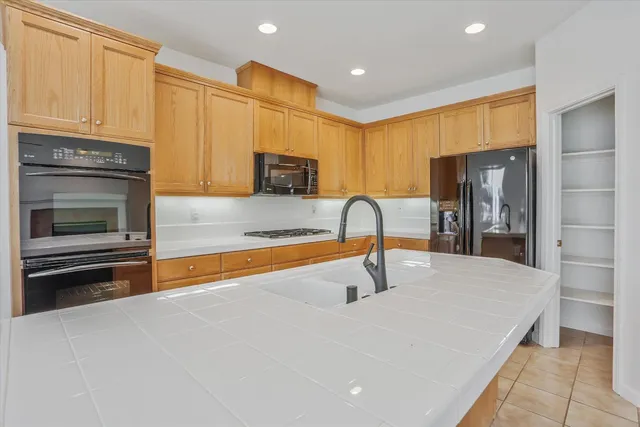 a view of kitchen with kitchen island stainless steel appliances refrigerator oven and cabinets