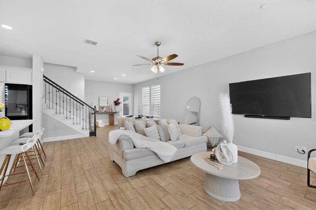 6040 Bursey Road Watauga, TX 76148 - Photo 15 of 39 This open-concept living area features wood-look tile flooring, light grey walls, and a ceiling fan