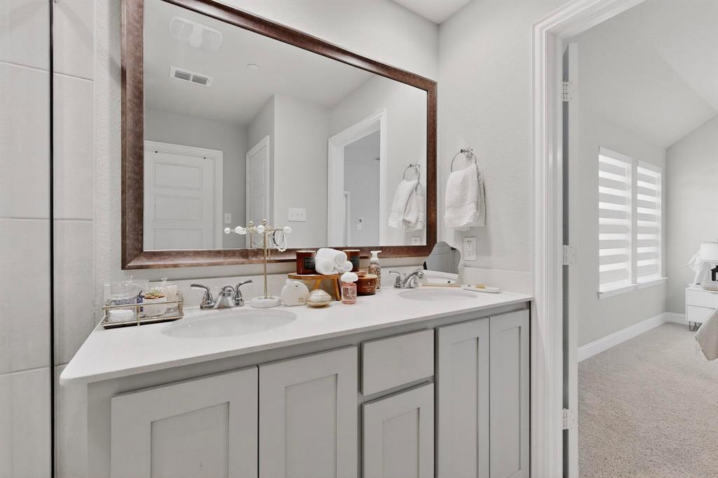 6040 Bursey Road Watauga, TX 76148 - Photo 26 of 39 This bathroom features a double vanity with light-colored cabinetry and a large framed mirror