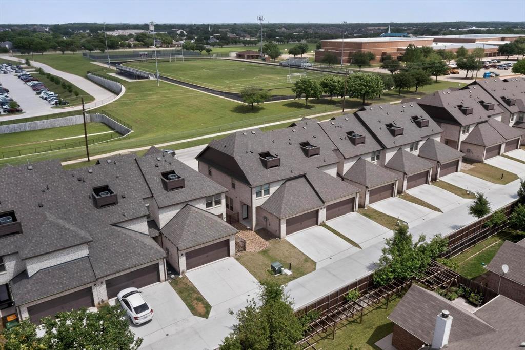6040 Bursey Road Watauga, TX 76148 - Photo 37 of 39 The property is part of a series of homes featuring a uniform architectural style, individual garages, and private driveways