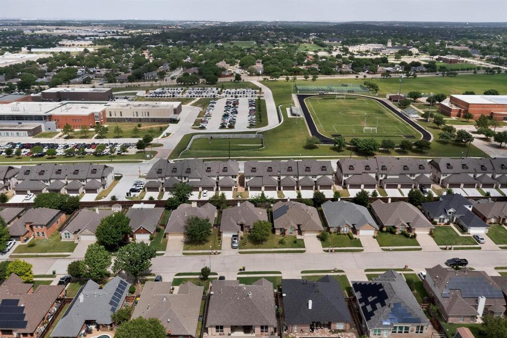 6040 Bursey Road Watauga, TX 76148 - Photo 38 of 39 Aerial view showcasing a residential area with a variety of home styles, green spaces, and a recreational field with a track