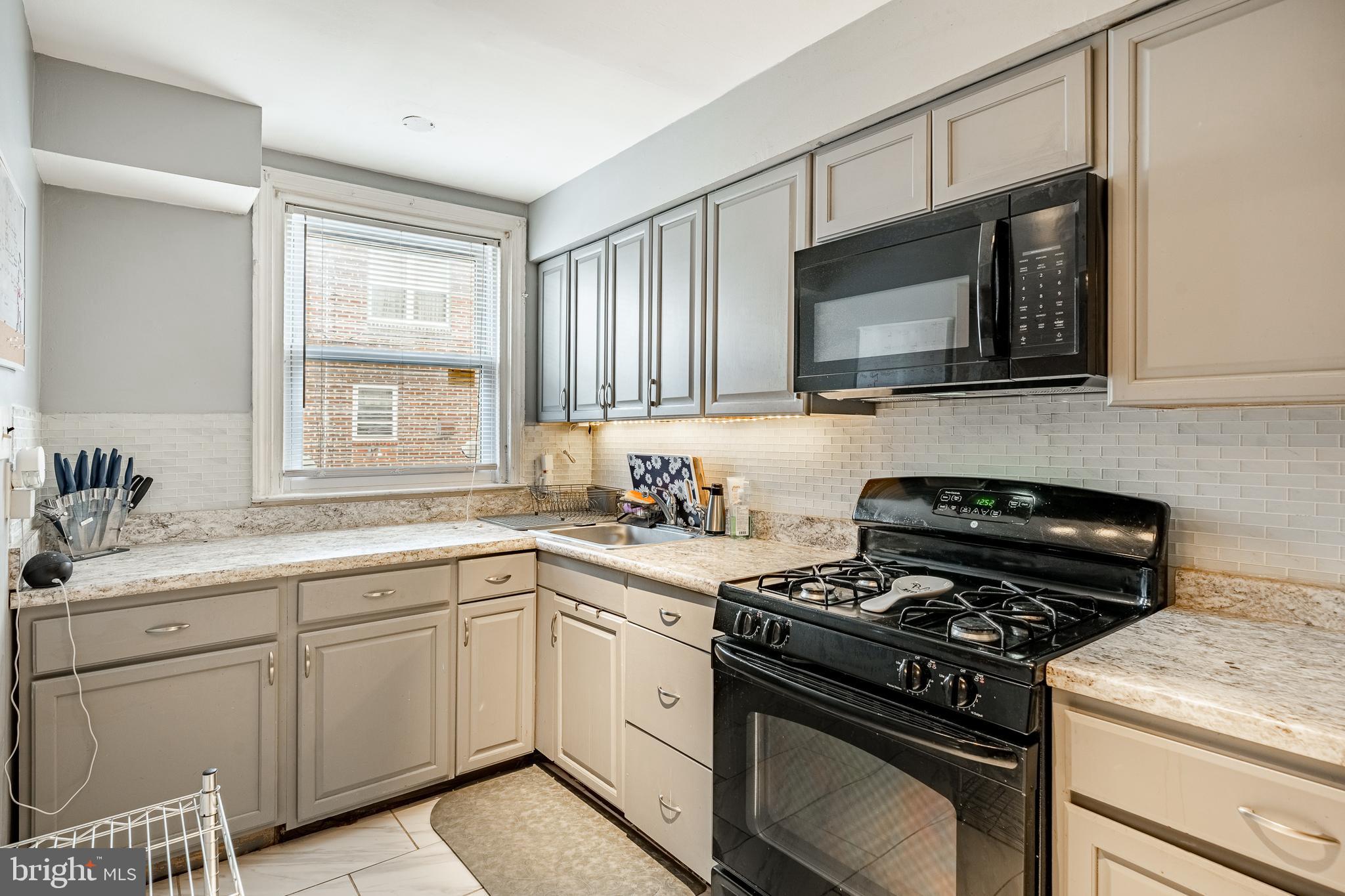 211 Wingate Road Upper Darby, PA 19082 - Photo 11 of 27 a kitchen with cabinets stainless steel appliances a sink and a window