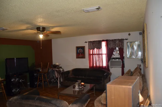 a living room with furniture a ceiling fan and a window