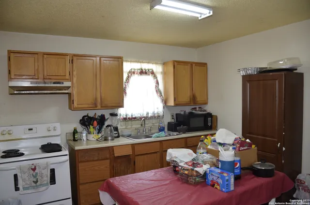 a kitchen with a refrigerator and a stove top oven