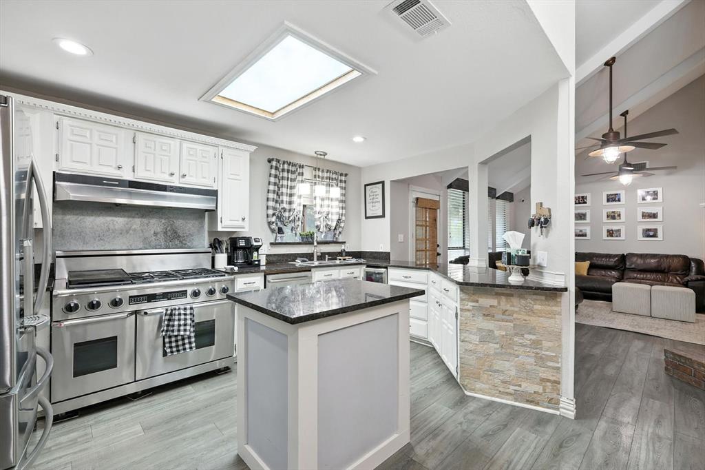 11005 Cowboy Lane Flower Mound, TX 76262 - Photo 14 of 14 a kitchen with stainless steel appliances kitchen island granite countertop a stove and a sink