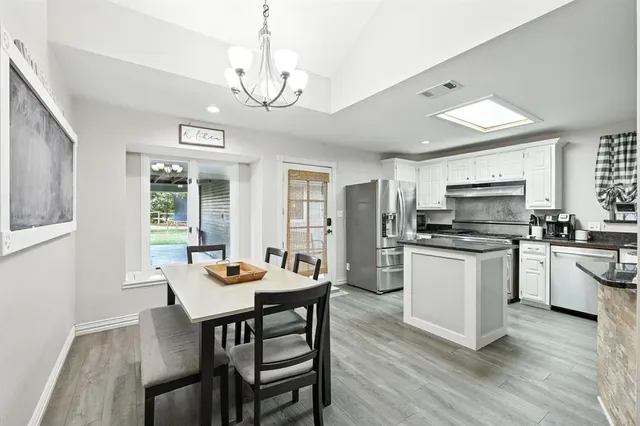 a kitchen with stainless steel appliances kitchen island granite countertop a stove and a sink