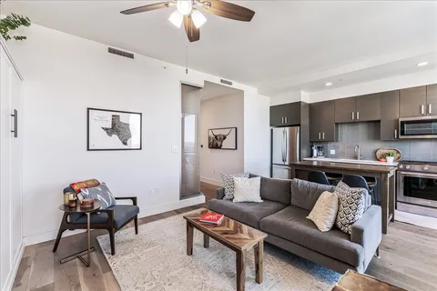 a living room with furniture kitchen view and a potted plant