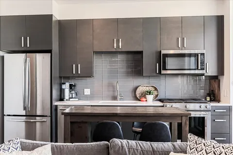 a kitchen with stainless steel appliances granite countertop a sink stove and refrigerator
