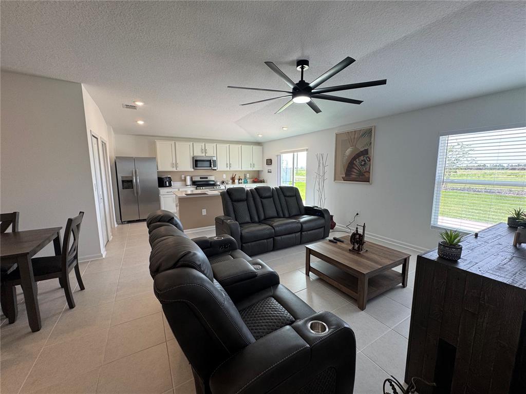 2405 Bluestone Road Haines City, FL 33844 - Photo 6 of 18 a living room with furniture a ceiling fan and a window