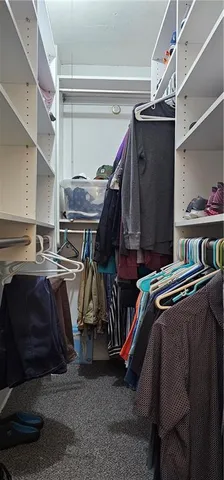 a view of walk in closet with clothes and shoes