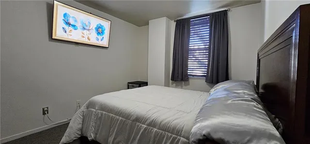 a bedroom with a bed and a painting on the wall