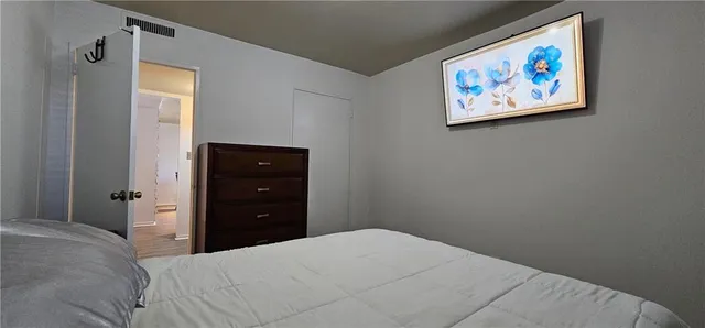 a bedroom with a bed and a painting on the wall