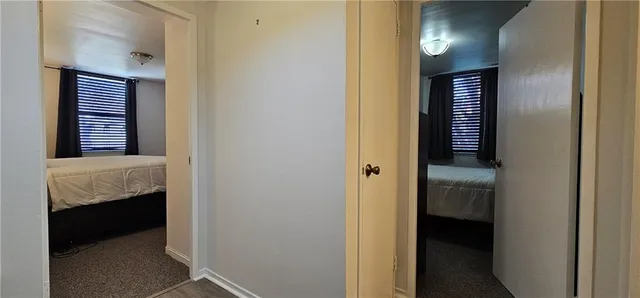 a view of a hallway with windows and a bathroom