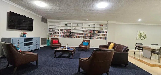 a work room with furniture a flat screen tv and gym equipment