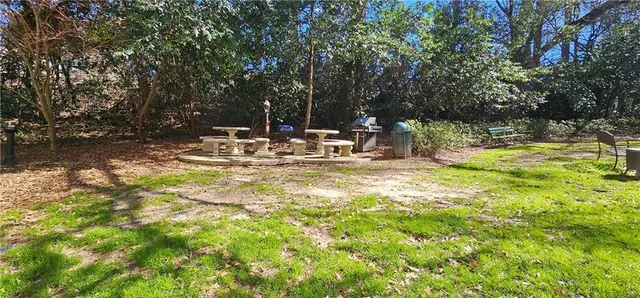 a view of backyard with swimming pool and trees