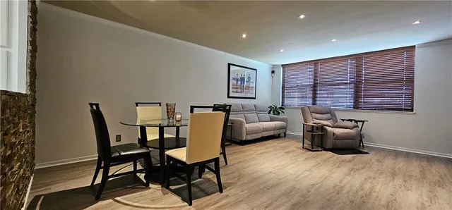 a living room with furniture two windows and a dining table