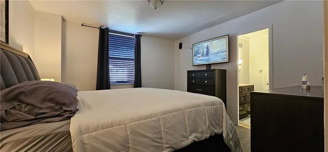 a bedroom with a bed and dresser with mirror