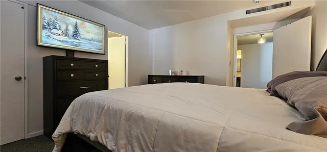 a bedroom with a bed and a painting on the wall