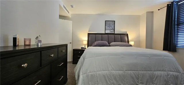 a bedroom with a bed and a night stand