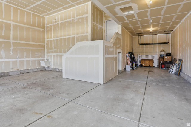 3636 West 910 South Syracuse, UT 84075 - Photo 58 of 70 Two-car deep garage with concrete flooring, unfinished drywall, and a built-in staircase