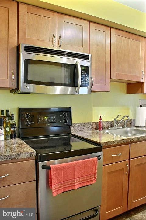 54 Ridge Road, Unit B Greenbelt, MD 20770 - Photo 4 of 9 a kitchen with stainless steel appliances granite countertop a stove and a microwave