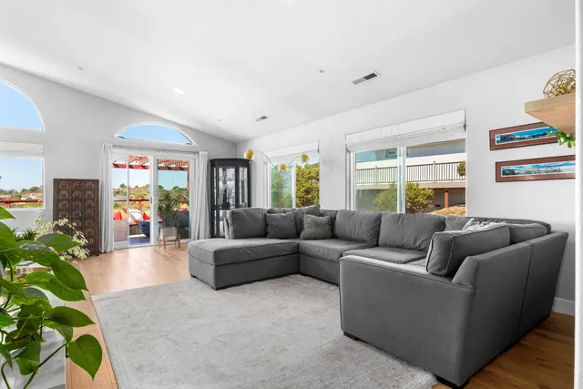 a living room with furniture a window and a potted plant