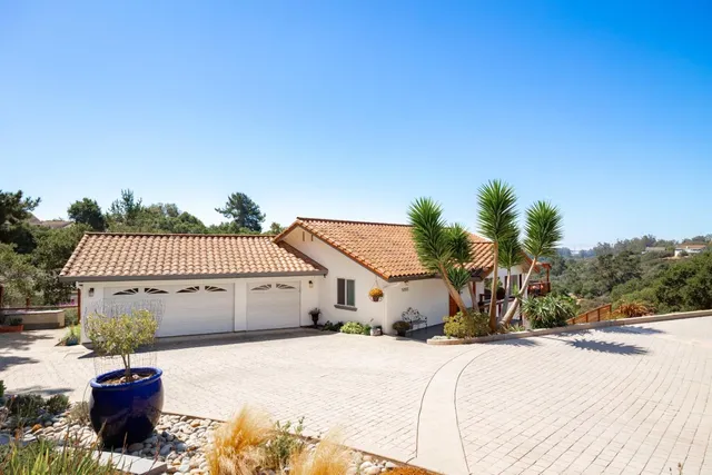 a view of a house with a yard and palm trees
