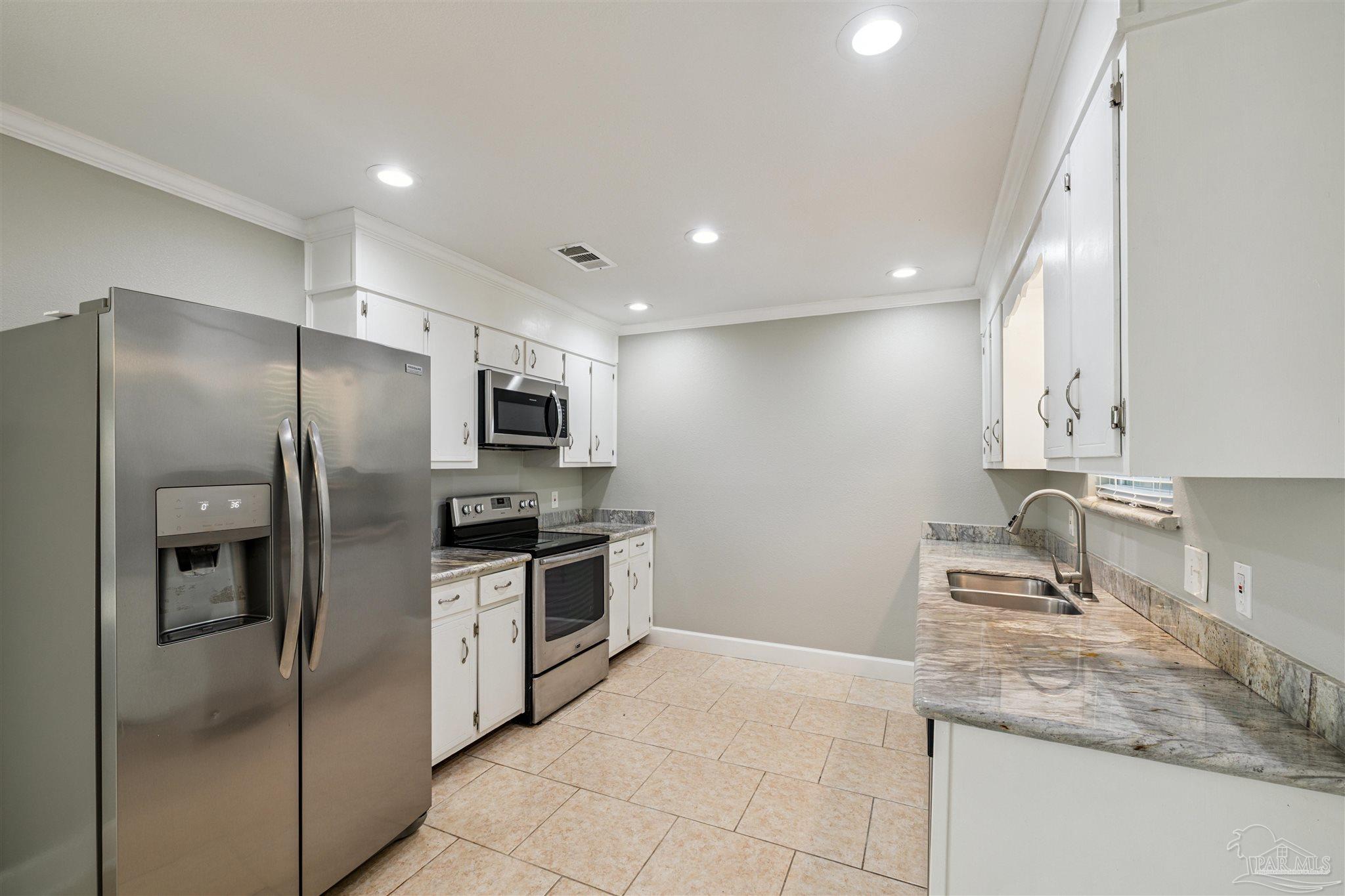 4250 Avenida San Marcus Pace, FL 32571 - Photo 13 of 23 a kitchen with stainless steel appliances granite countertop a refrigerator and a sink