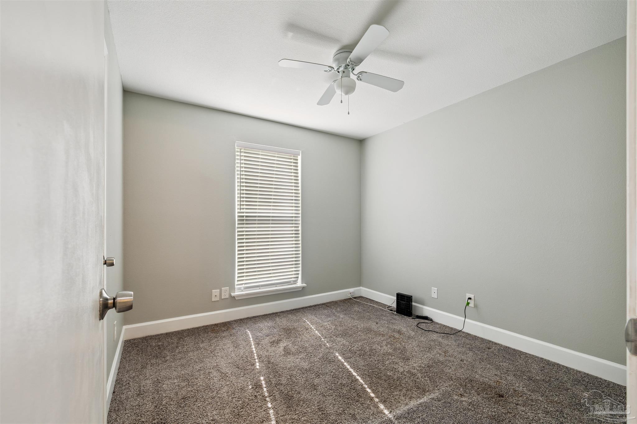 4250 Avenida San Marcus Pace, FL 32571 - Photo 16 of 23 an empty room with a ceiling fan and window