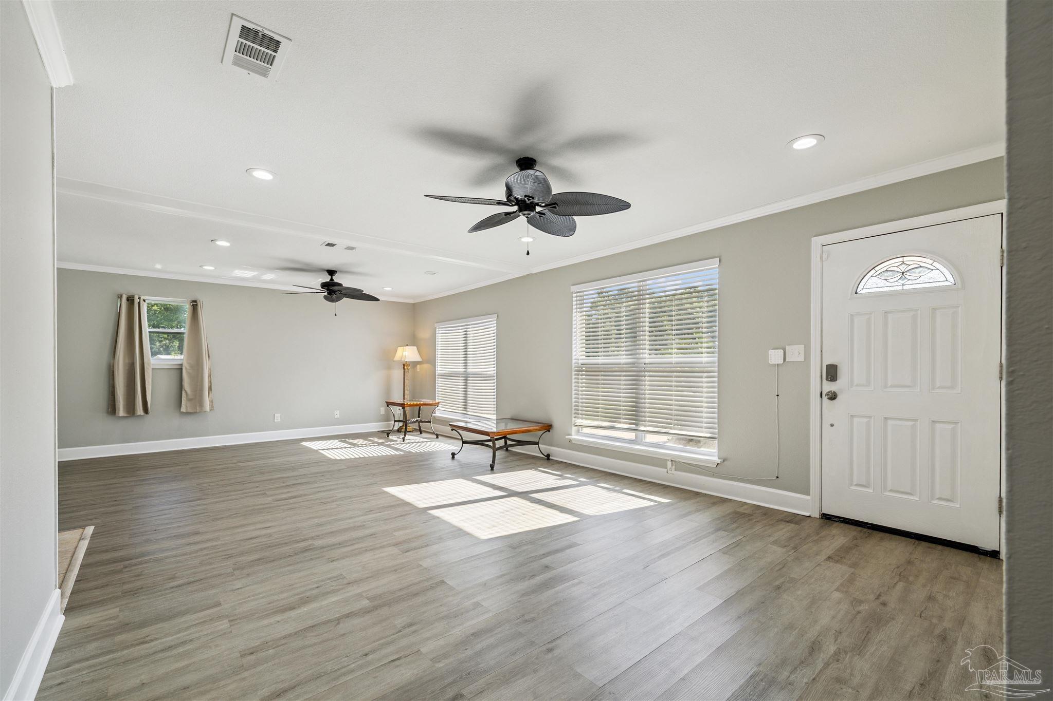 4250 Avenida San Marcus Pace, FL 32571 - Photo 8 of 23 a view of an empty room with a window and wooden floor