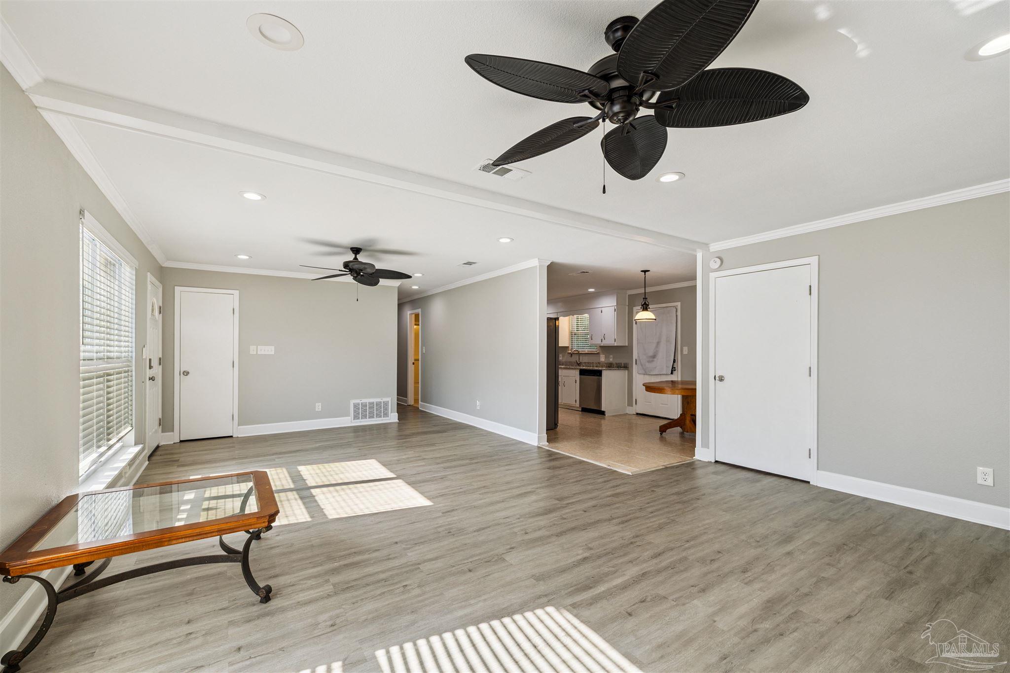 4250 Avenida San Marcus Pace, FL 32571 - Photo 10 of 23 a living room with wooden floor furniture and a ceiling fan