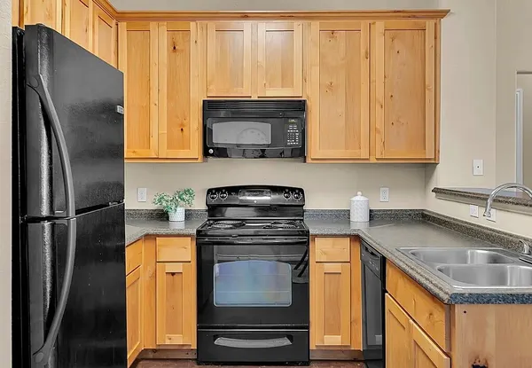 a kitchen with granite countertop a sink stove and refrigerator