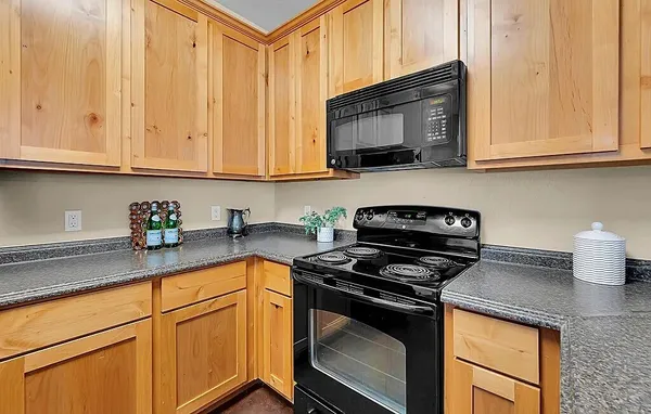 a kitchen with stainless steel appliances granite countertop white cabinets sink and a granite counter top