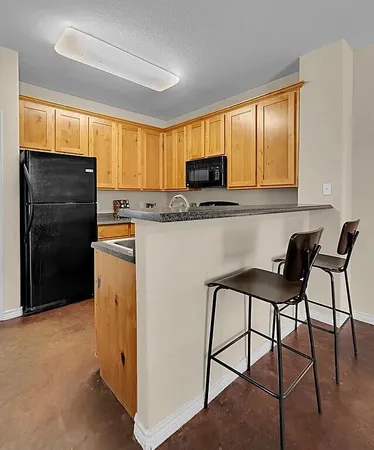 a kitchen with appliances cabinets and a chair