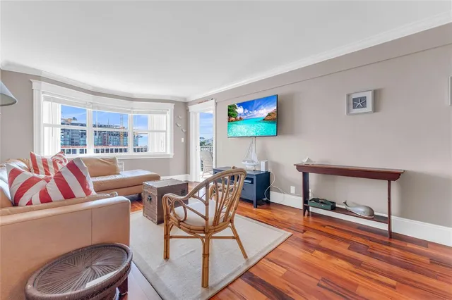 a living room with furniture a flat screen tv and a floor to ceiling window