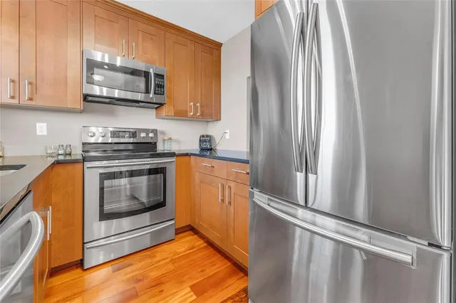 a kitchen with stainless steel appliances granite countertop a stove a sink and a microwave